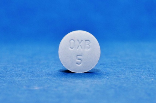 Illustration d'un flacon de Ditropan sur fond de drapeau français